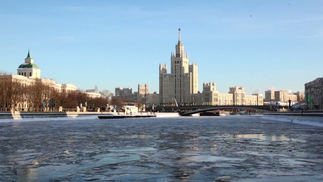 Ship floats on icy river, residential complex of Stalin era