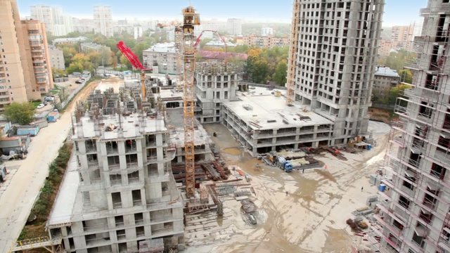 Construction site in foreground of cityscape of dormitory area
