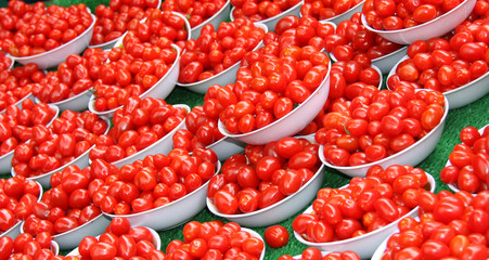 A Display of Small Red Plum Tomatoes in White Bowls.