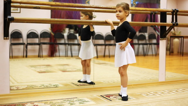 little girl crouches in ballet position