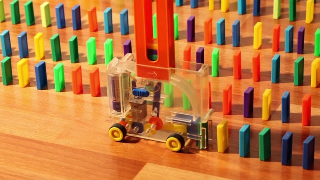 Toy machine moves and put domino blocks