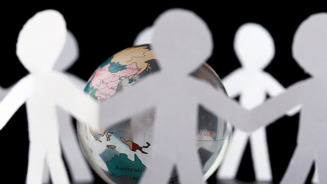 paper people stand and rotates around transparent globe