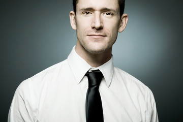 Young businessman in white shirt in confident pose.