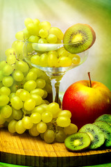 Grapes in glass, red apple and kiwi