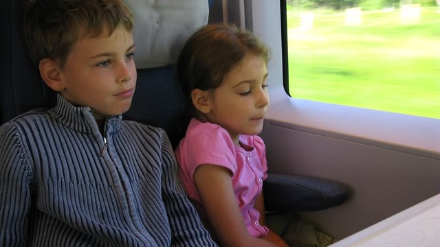 Little girl and boy travel by fast train, time lapse