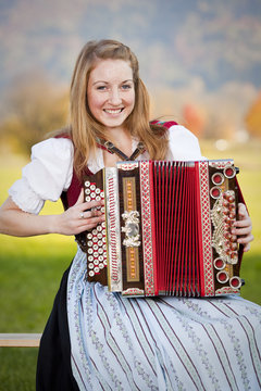 bayerische Frau im Dirndl mit Akkordeon