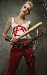 Punk girl with a bat behind broken glass