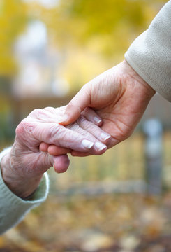 Senior And Young Holding Hands