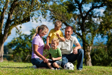 Fototapeta premium Family with children and football on a meadow