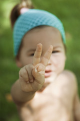 A child shows his hands the symbol of peace