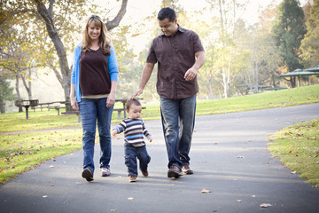 Happy Mixed Race Ethnic Family Walking In The Park