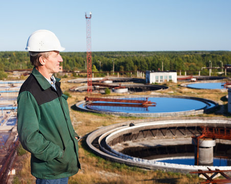 Manual Worker In White Hardhat Near Sewage Treatment Basin