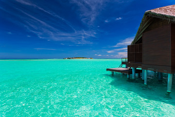 Over water bungalow with steps into blue lagoon