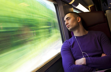 Portrait of a young handsome man in the train - obrazy, fototapety, plakaty