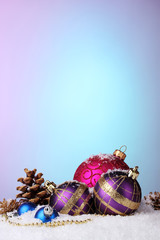 beautiful Christmas balls and cones on snow on bright background