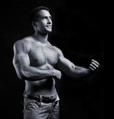 young muscular man on black background - obrazy, fototapety, plakaty
