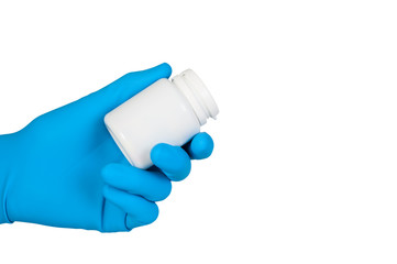 Hand in blue rubber glove holds jar of pills isolated on white b