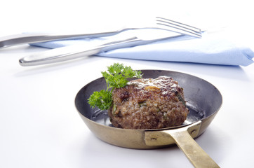 frisch gebratene Frikadelle mit Petersilie liegt in einer Messin