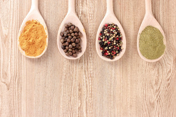 spices in the spoons on wooden background