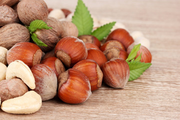 nutmeg, peanuts and almonds on wooden background