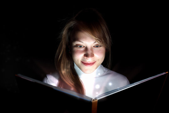 Young woman reading a magic book