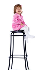 The little girl sits on a high chair