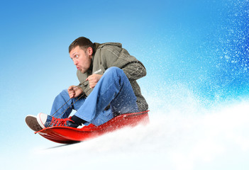 Fototapeta na wymiar Młody człowiek leci na sanki w śniegu, pojęcie