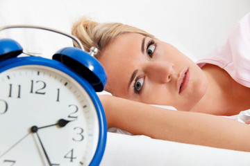 Schlaflos mit Uhr in der Nacht.