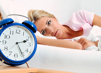 Schlaflos mit Uhr in der Nacht.