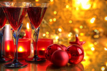 Closeup of red wine and baubles,candle lights.