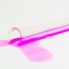 test tubes with colorful substances spilled on a white table