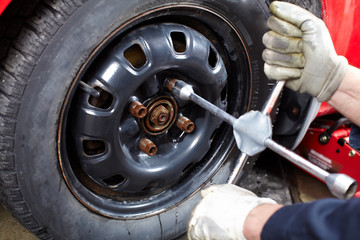Auto mechanic changing a tire.