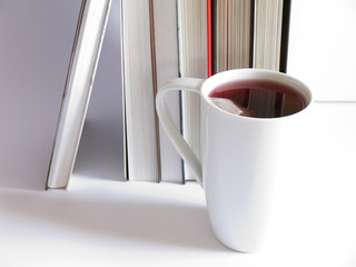 white cup of tea and books