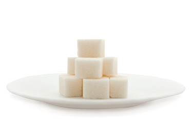 sugar cubes on a plate over white background