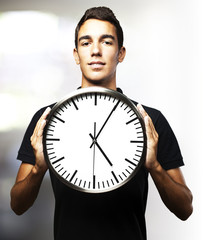 young man holding clock