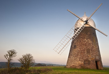 Traditional old wooden and brick windmill at sunset