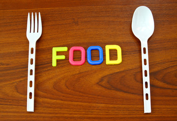food in colorful letters with plastic spoon and fork
