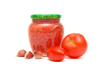 Tomatoes, garlic and Caucasian sauce adjika in a glass jar on a