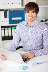 mann arbeitet am laptop im büro