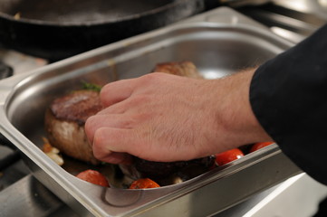 der Koch bei der Zubereitung eines Rumpsteak