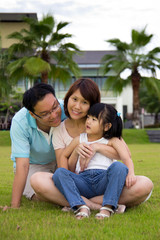 Happy family sits on grass field