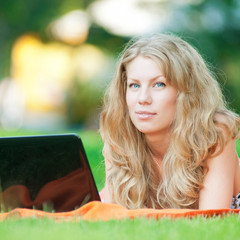 Young woman with laptop at park