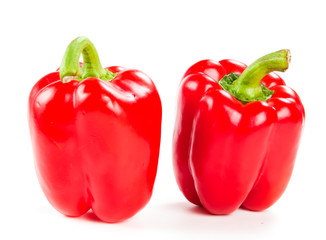 two fresh red peppers on white