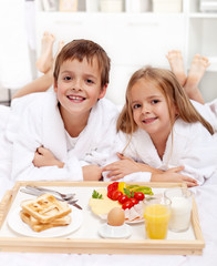 Obraz na płótnie Canvas Happy Kids posiadające śniadanie w łóżku