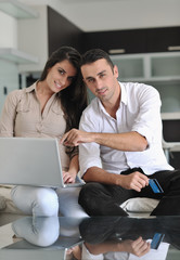 joyful couple relax and work on laptop computer at modern home