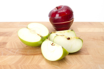 red and green apple cut and slice on wood plate.