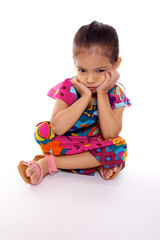 enfant triste assise sur fond blanc