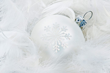 White Christmas bauble on white feathers