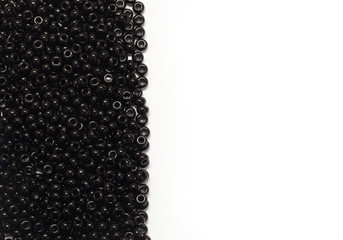 black pearls scattered on a white background with place for text