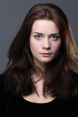 Fototapeta premium Beautiful young woman in grey background